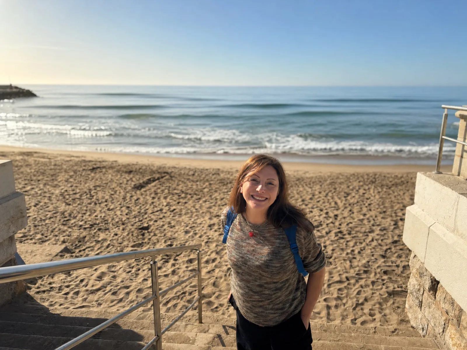 Paola Arcila sonriendo en la playa, con el mar de fondo